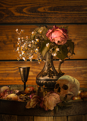  skull, faded roses, old fruit and a chalice sitting on a barrel